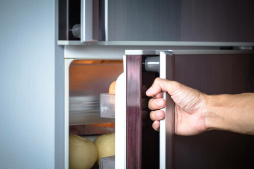 A person opening a fridge door.
