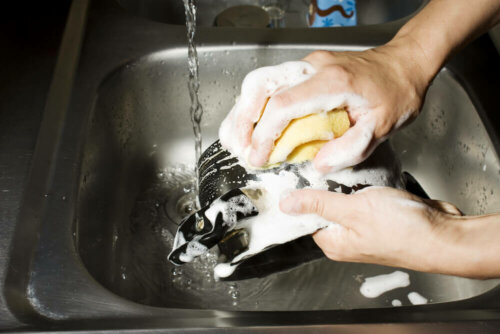 A person washing the dishes.