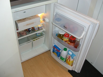 A small refrigerator in a corner.