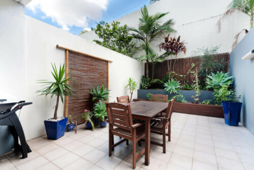 A tiled patio with a touch of green.