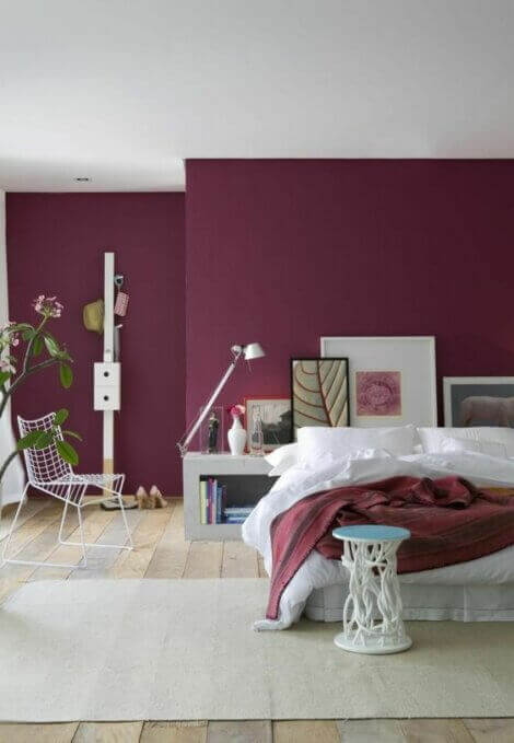 Bedroom with wine colored walls combined with white decor.