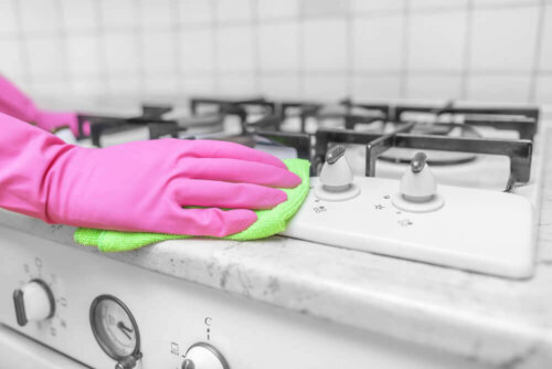 Someone clean a stove top.