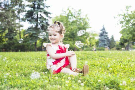 Little girl sitting in the grass to illustrate having chidren at a family picnic