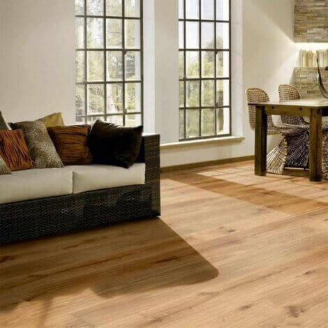 Wood floor with a sofa by the windows.