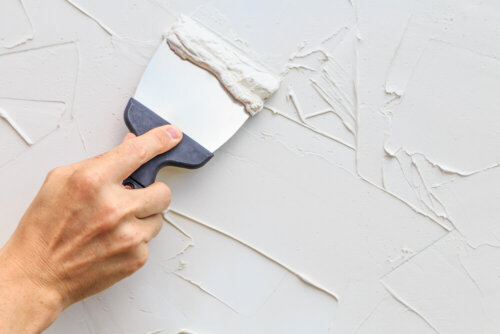 A person repairing their walls.