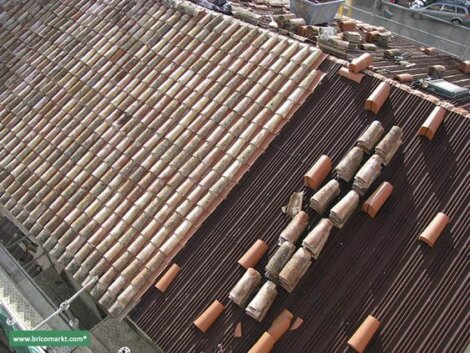 A roof with clay tiles being applied