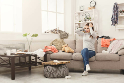A woman in a messy living room.