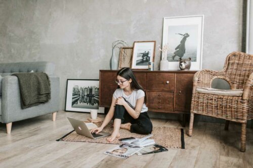 A woman sitting on the floor of her city apartment.