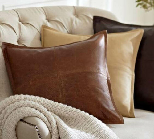 Some faux leather pillows on a sofa.