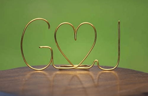 The initials of two people in gold wire.
