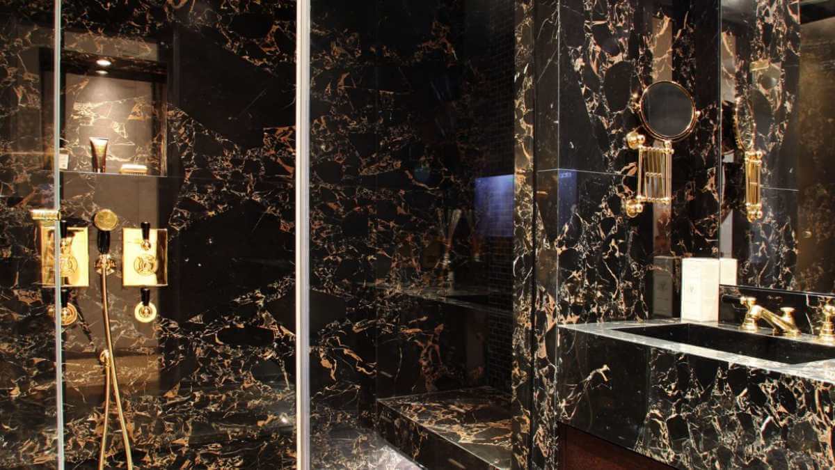 A dark restroom with gold decor