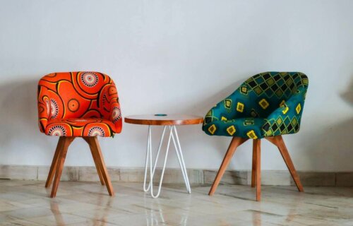 Some multicolored upholstered armchairs by a table.