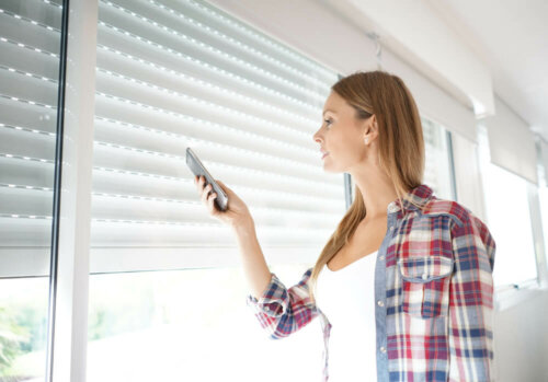 A woman closing the blinds.