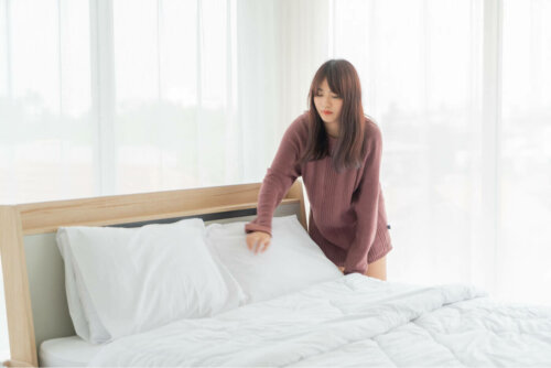 A woman making her bed.