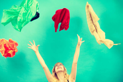 A woman throwing clothes up in the air.