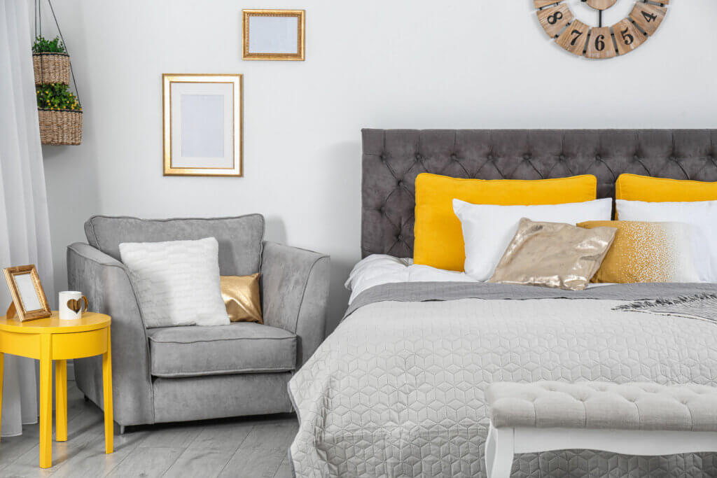 A gray bedroom with pops of mustard and gold.