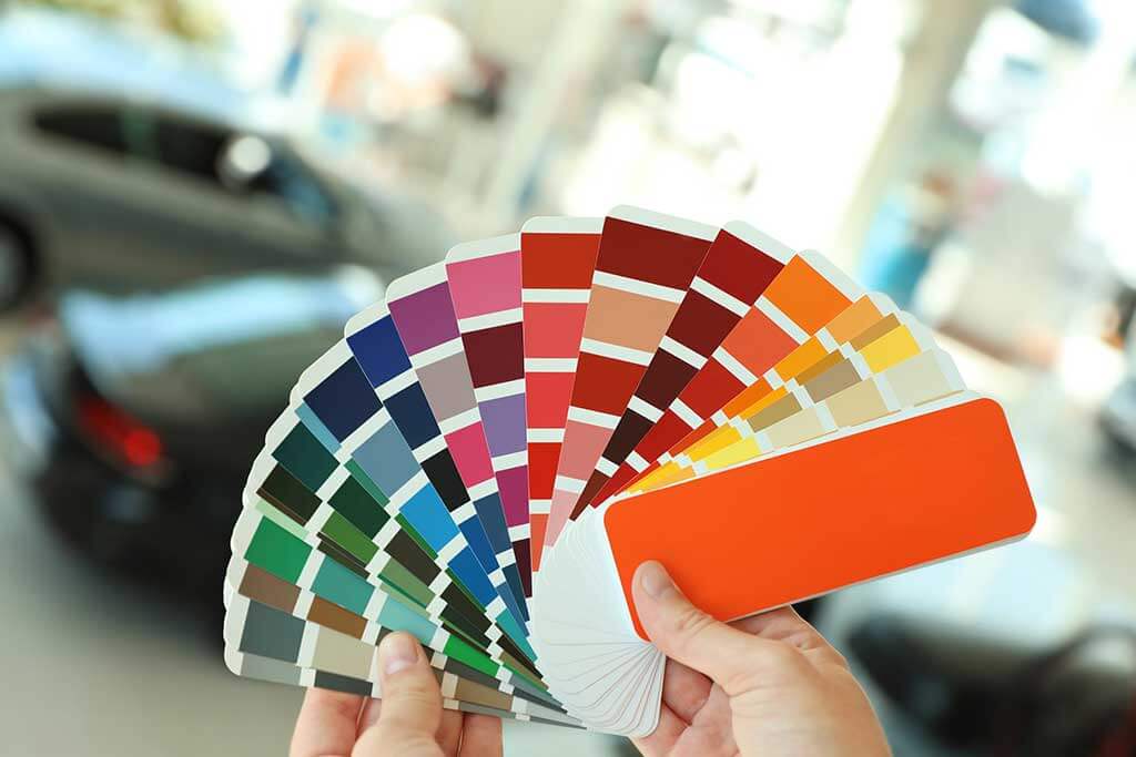 A person looking at paint samples to choose a color.