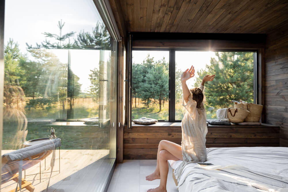 A woman waking up to energy efficient windows 