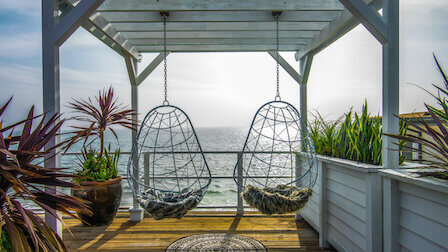 Two hanging basket chairs overlooking the ocean; a design from Stay Here.